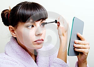 Woman putting mascara