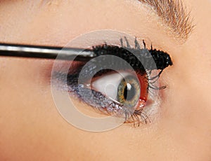 Woman putting on mascara