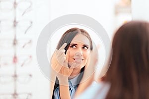 Woman Putting on Medical Contact Lenses in the Mirror