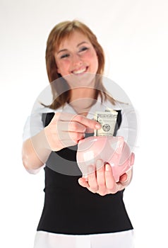 Woman putting money in a Piggy Bank