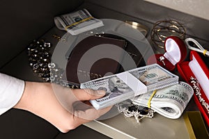 Woman putting money into steel safe