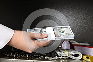 Woman putting money into steel safe