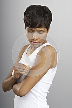 Woman Putting Nicotine Patch On Arm photo