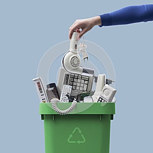 Woman putting an old appliance in the waste bin