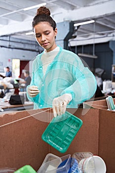 Woman putting plastic wastes at the sorting box