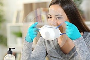 Woman putting mask avoiding coronavirus at home photo