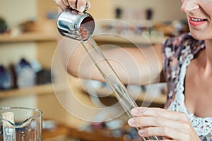 Woman putting red gemstones in a tube