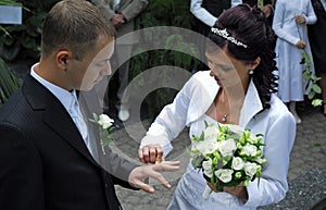 Woman putting ring on groom