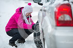 Woman putting snow chains