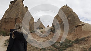Woman putting on sunglasses visiting Cappadocia stones