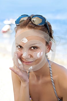 Woman putting sunscreen