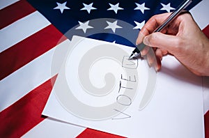 Woman putting tick on the paper for vote. Political changes in the country. Copy space place. Elections in the USA. American flag