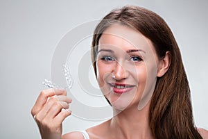 Woman Putting Transparent Aligner In Teeth