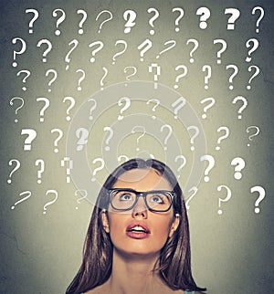Woman with puzzled face expression question marks above her head looking up