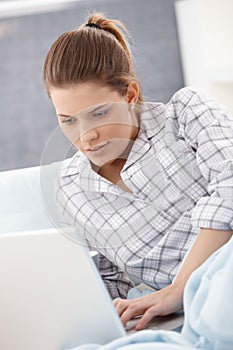 Woman in pyjama using laptop