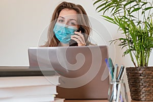 Woman in quarantine for Coronavirus wearing protective mask and smart working
