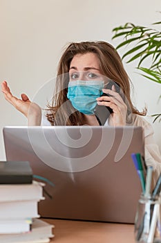 Woman in quarantine for Coronavirus wearing protective mask and smart working