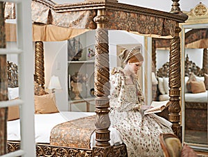 Woman, queen and book with reading for renaissance, royalty aesthetic and confidence on palace bed. Monarch, wealthy