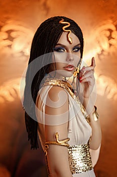 Woman queen Cleopatra art photo. Creative golden makeup Black hair braids. Carnival ethnic egypt costume dress