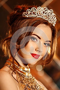 Woman queen princess in crown and lux dress, lights party background Luxury girl Long shiny healthy volume hair Waves Curls