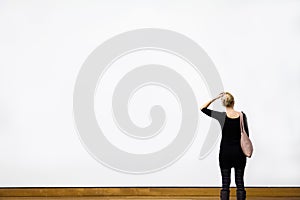 Woman Questioning in front of a Blank Wall