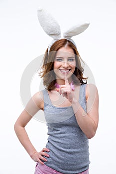 Woman in rabbit ears showing finger over lips
