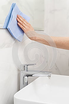 Woman with rag cleaning bathroom at home