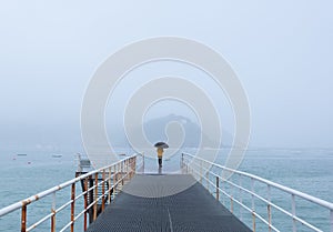 Woman in the rain on a jetty in the city of Donostia-San Sebastian.