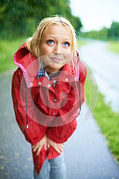 Woman, rain and raincoat in nature, thinking and cold from weather, winter and outdoors. Female person, wet and red coat