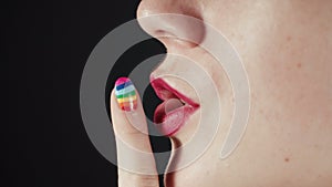 Woman with rainbow manicure showing quiet gesture