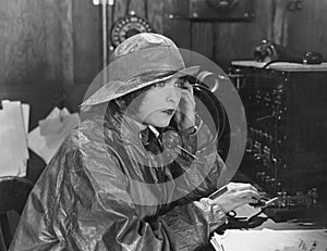 Woman in raincoat sending message in Morse code