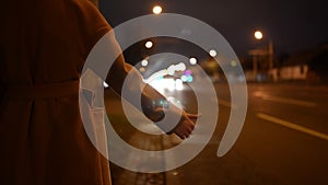 Woman raise her hand to stop the car on the night road.