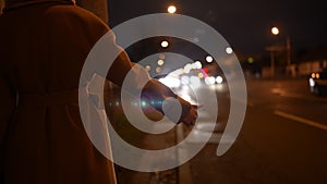 Woman raise her hand to stop the car on the night road.