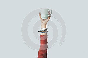 Woman raised arm up holding coffee cup
