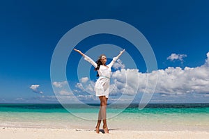 Woman with raised arms on beach