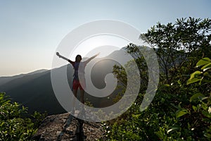 Woman raised arms on mountain top