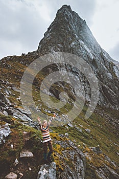 Woman raised hands enjoying mountain landscape travel hiking alone in Norway