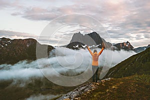 Woman raised hands over clouds in mountains sustainable travel vacations