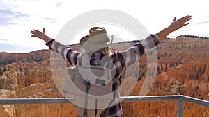 Woman Raised Hands Upwards While Standing On Observation Deck Overlooking Canyon
