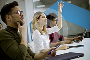 Woman raised her hand up for question in conference meeting