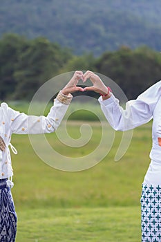 woman raised her hands and made heart symbol to express meaning of love friendship and kindness to her friends and lovers. woman