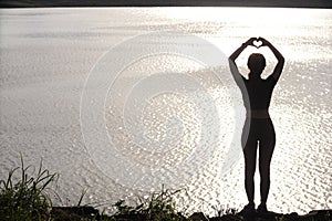 woman raised her hands and made heart symbol to express meaning of love friendship and kindness to her friends and lovers. woman