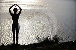 woman raised her hands and made heart symbol to express meaning of love friendship and kindness to her friends and lovers. woman