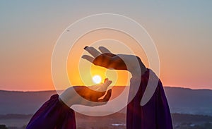 Woman raises arms in lavander field at sunset enjoys sunset in purple flower field. Serene floral setting. Setting sun