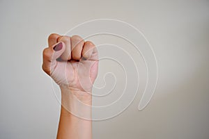 Woman raises fist feminist vindication with purple nails photo