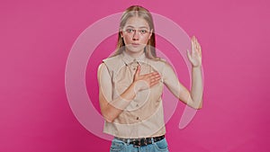 Woman raising hand to take oath, promising to be honest and to tell truth, keeping hand on chest