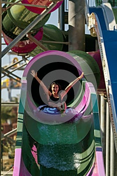 Woman raising hands having fun on a tubing the water slide