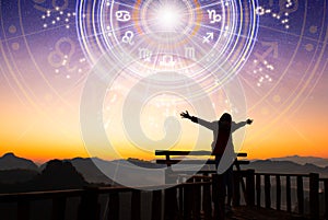 Woman raising hands looking at the sky. Astrological wheel projection, choose a zodiac sign. Trust horoscope future predictions,