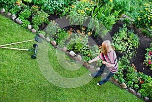 Woman rake in flower garden