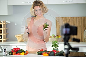 woman with raw vegetables recording cookery blog